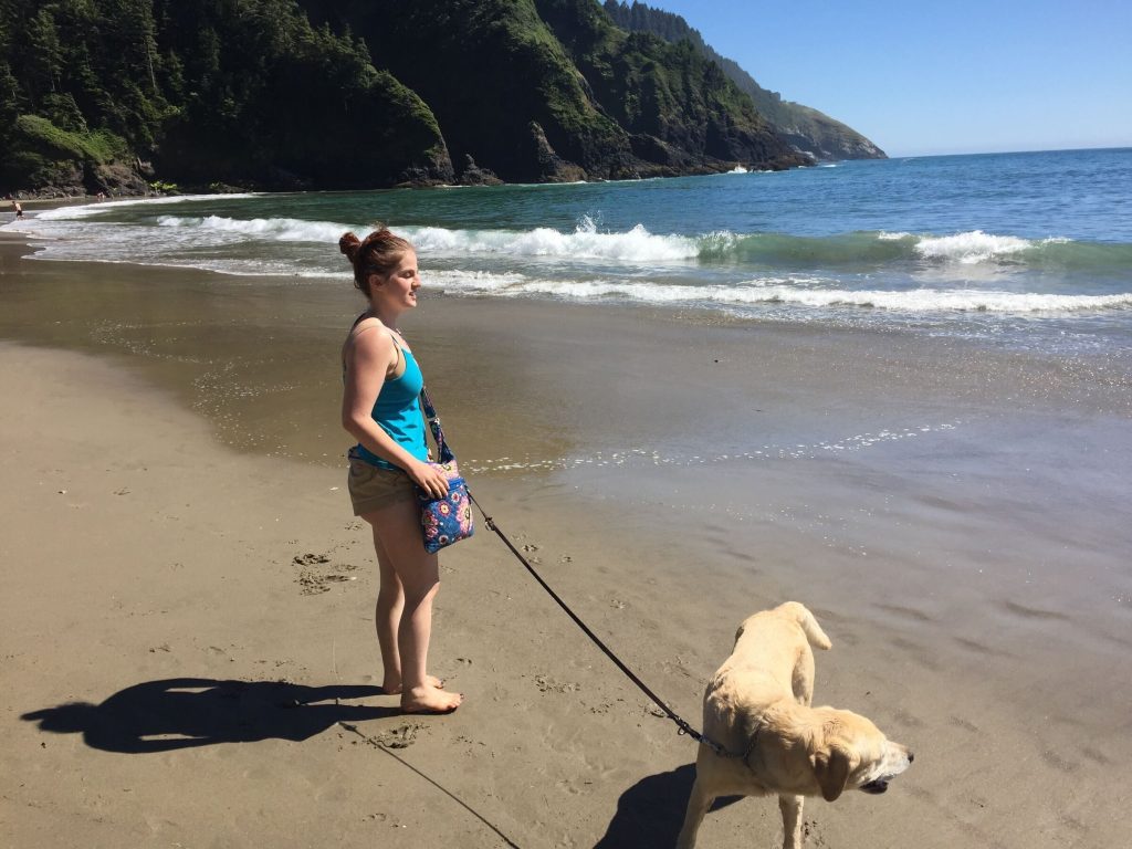 Megan and Suri on a Pacific Northwest beach, both looking out at the water.